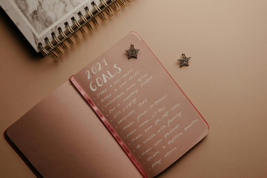 Top view of a 2021 goals notebook with handwritten list and star decorations, ideal for planning inspiration.
